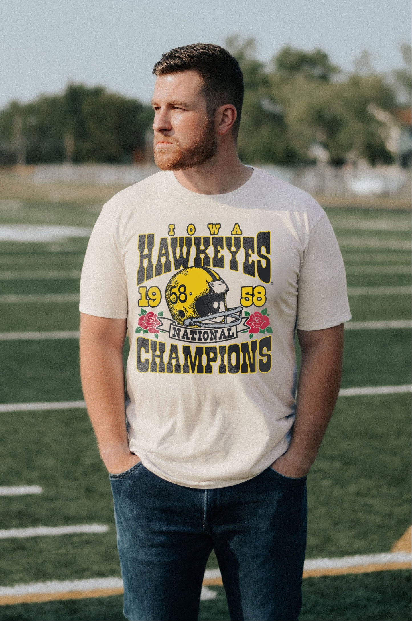 Man wearing a vintage 'Iowa Hawkeyes 1958 National Champions' t-shirt on a football field